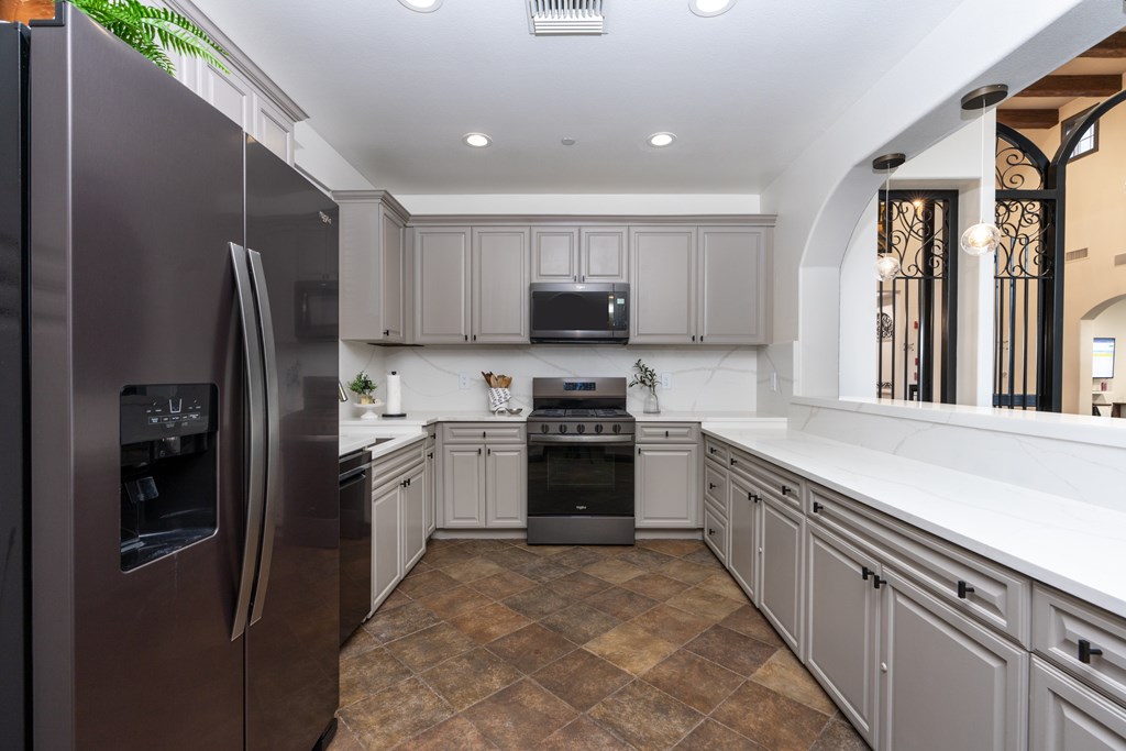 A modern kitchen with a refrigerator on the left and a stove on the right.