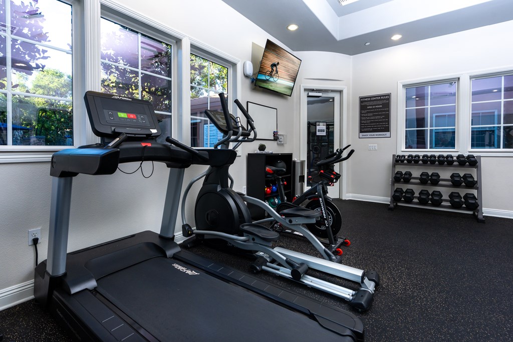 A black treadmill with a digital display in a well lit room.