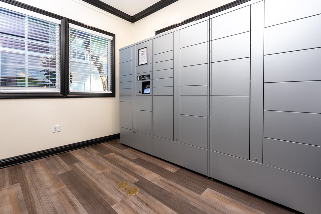 A room with a wooden floor and a wall of metal lockers.