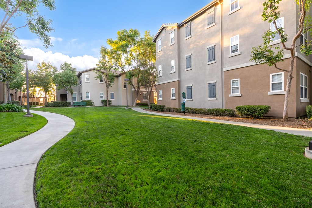 A grassy area in front of apartment buildings.
