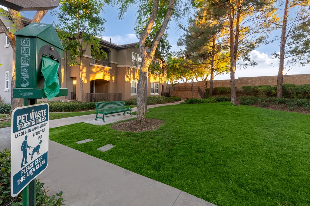 A sign in front of a building that says "Pet Waste Transmitters Leash Off After 15".