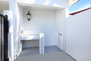 A white bathroom with a black fence and a black lantern.