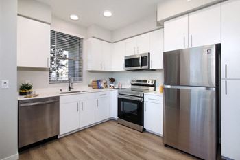 A modern kitchen with stainless steel appliances and white cabinets.