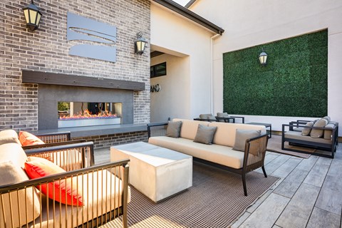 A patio with a fireplace and seating area.