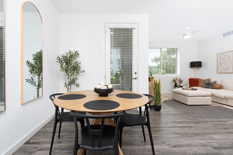 A modern dining room with a round table and chairs.