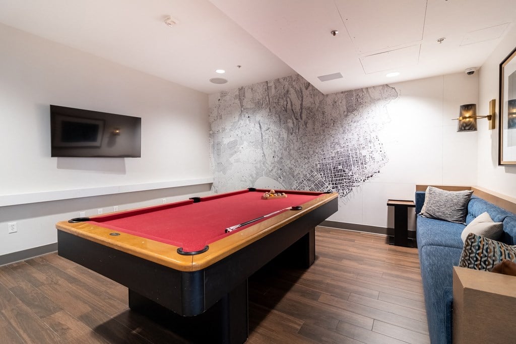 a billiards table in a living room with a red pool table