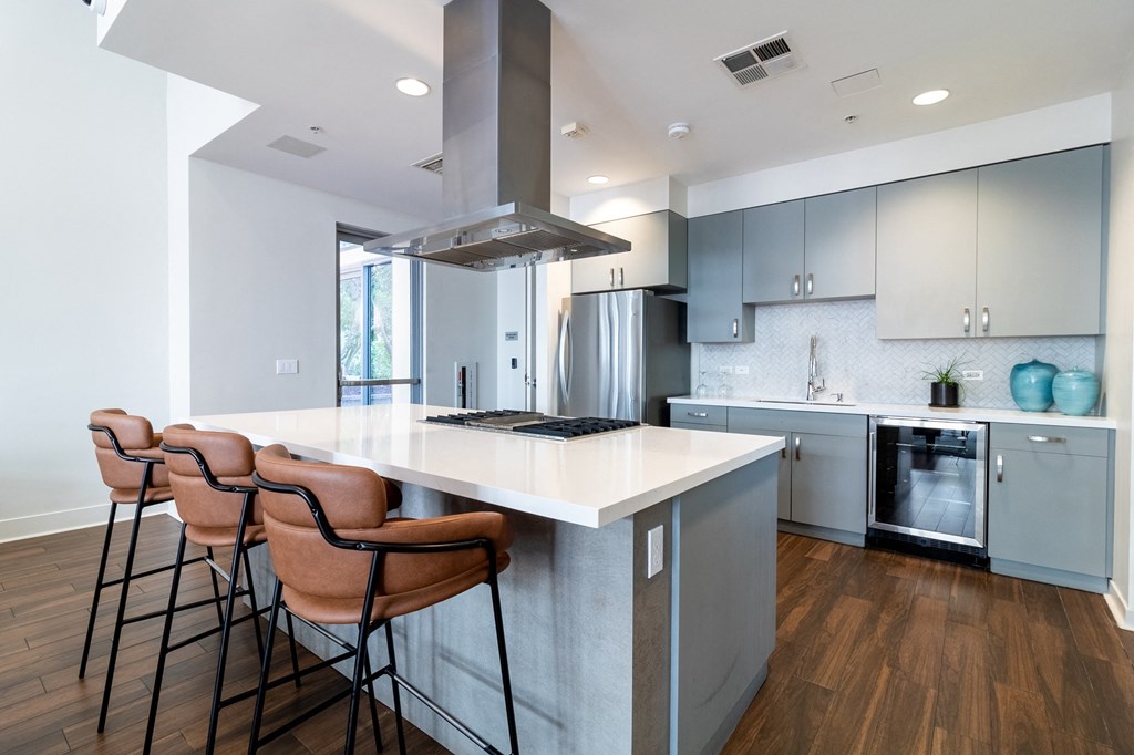 a kitchen with a large island with four stools in front of it