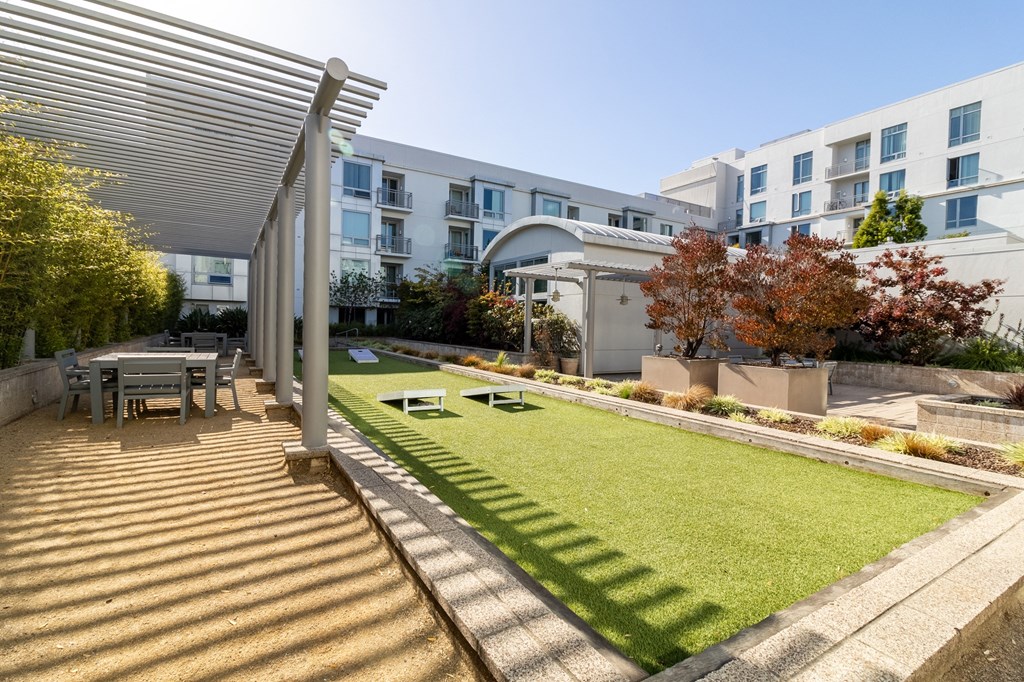 a backyard with a lawn and a table and chairs