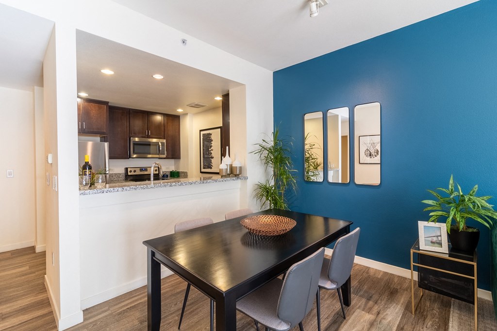 a dining room with a blue wall and a table and chairs