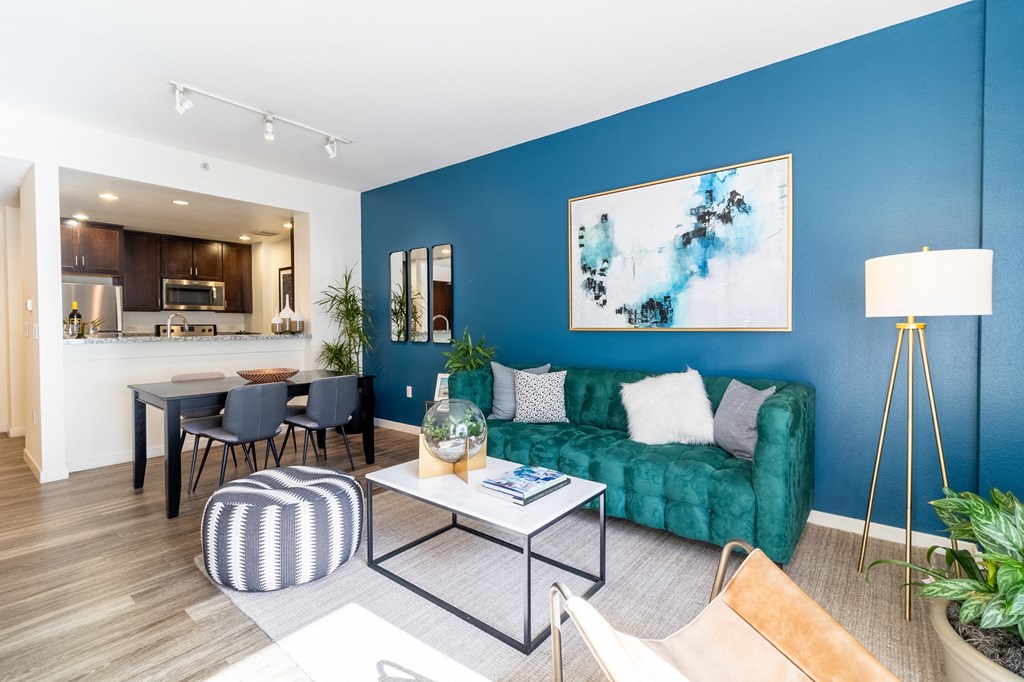 a living room with a blue wall and a green couch