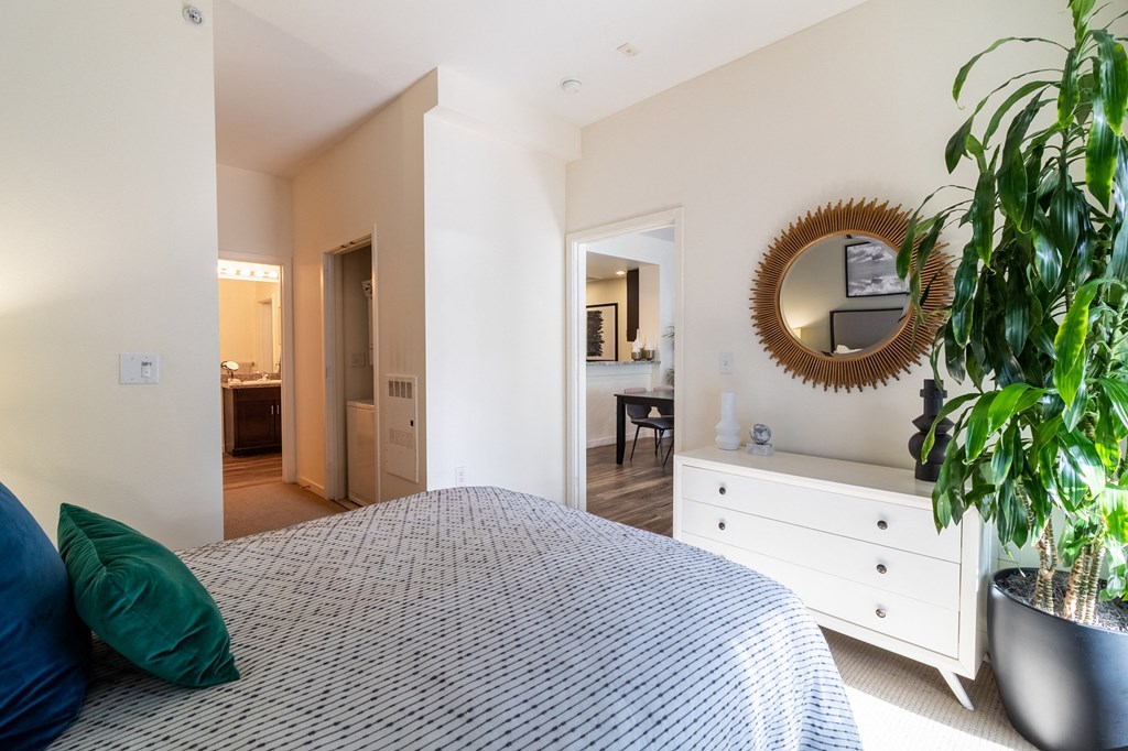 a bedroom with a bed and a dresser and a mirror