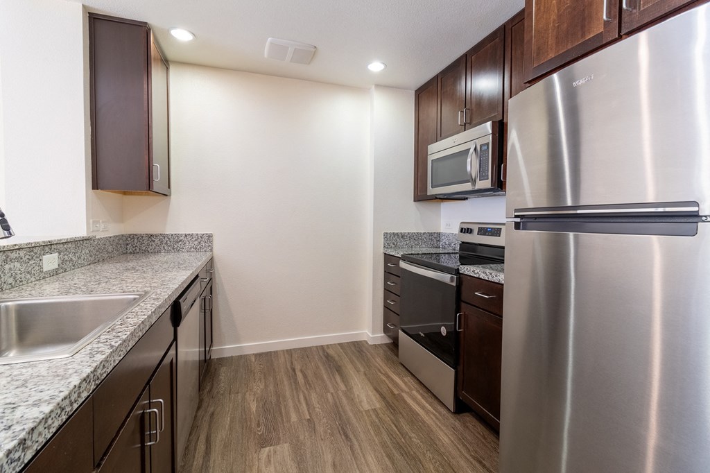 a kitchen with stainless steel appliances and marble counter tops