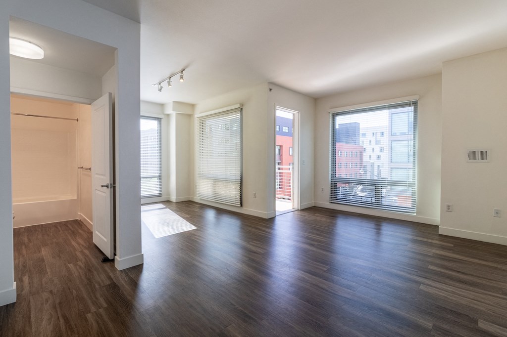 an empty living room with wood flooring and a large window