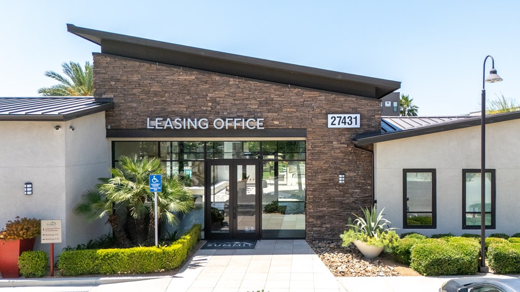 The image shows a modern building with a glass entrance and a sign that reads "Leasing Office 27431".