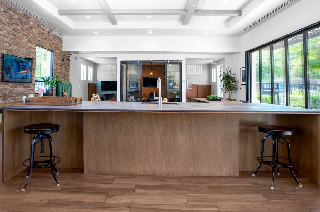A long wooden bar with two stools in front of it.