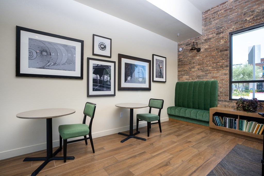A room with a white table and green chairs.