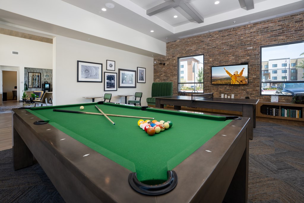A pool table with a green felt cloth and a set of pool cues on it.