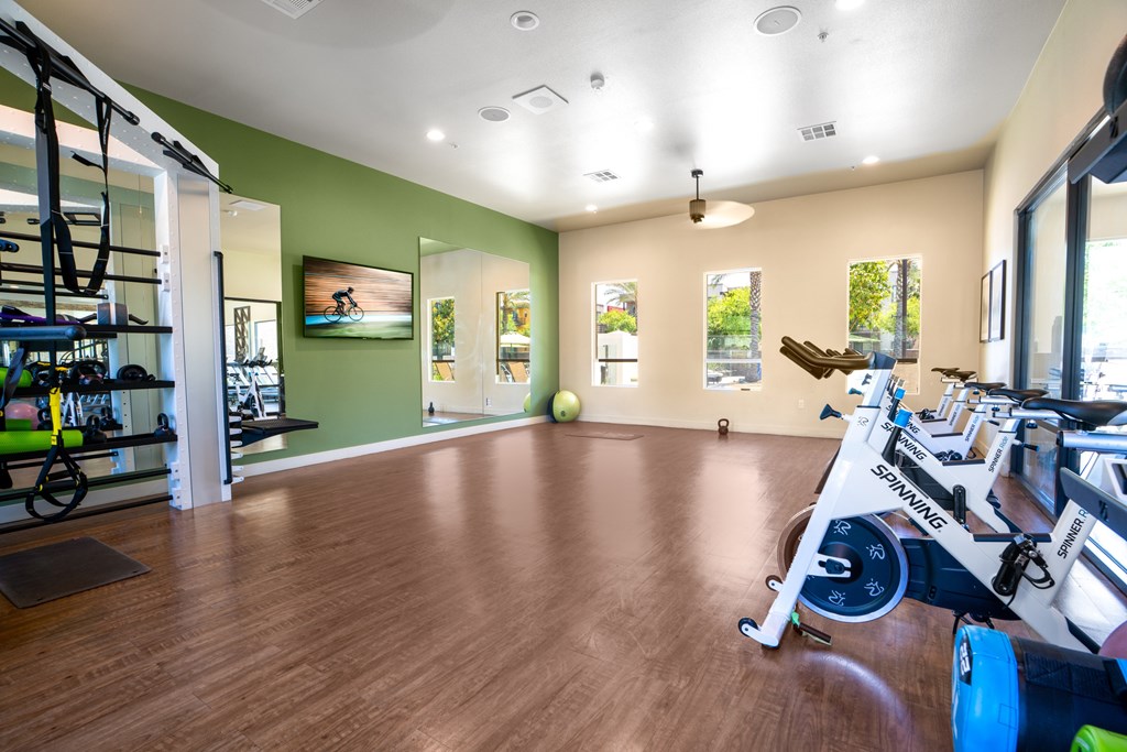 A gym with a green wall and wooden floors.