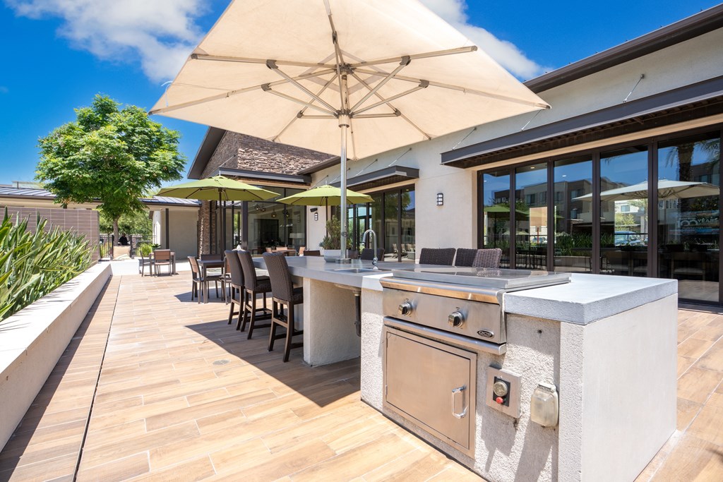 A patio with a table and chairs under a large umbrella.