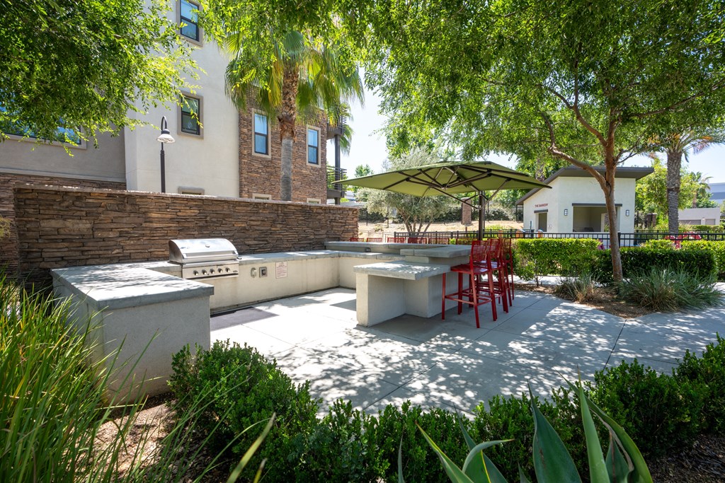 A patio with a table and chairs under a tree.
