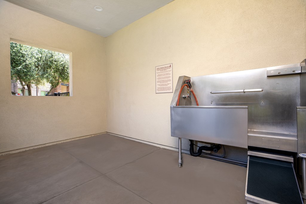 A room with a stainless steel appliance and a window.