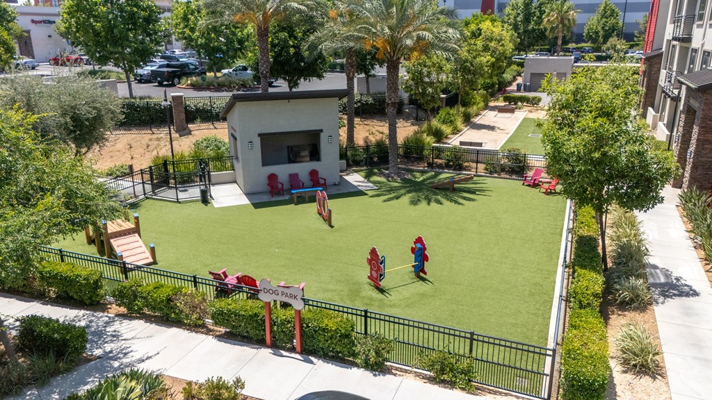 A small building with a red sign in front of a green lawn.