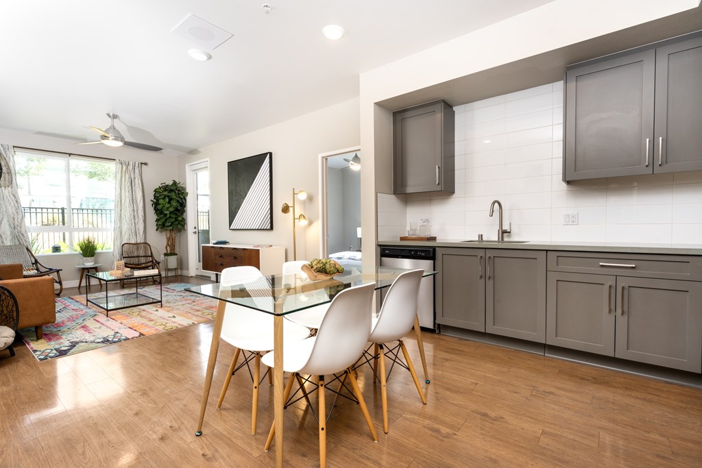 A modern kitchen with a dining table and chairs.