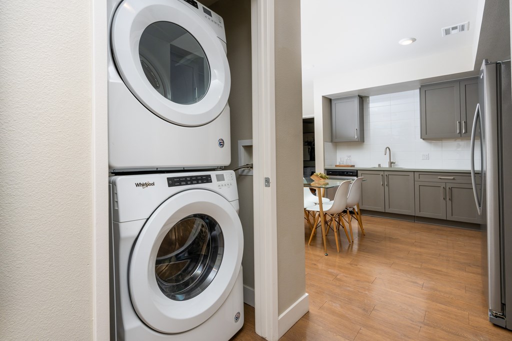 A white Whirlpool washing machine and dryer in a modern kitchen.