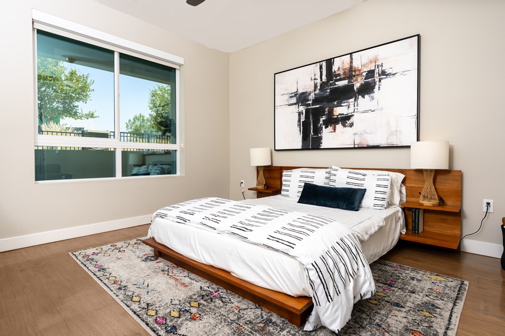 A bedroom with a large bed and a painting on the wall.