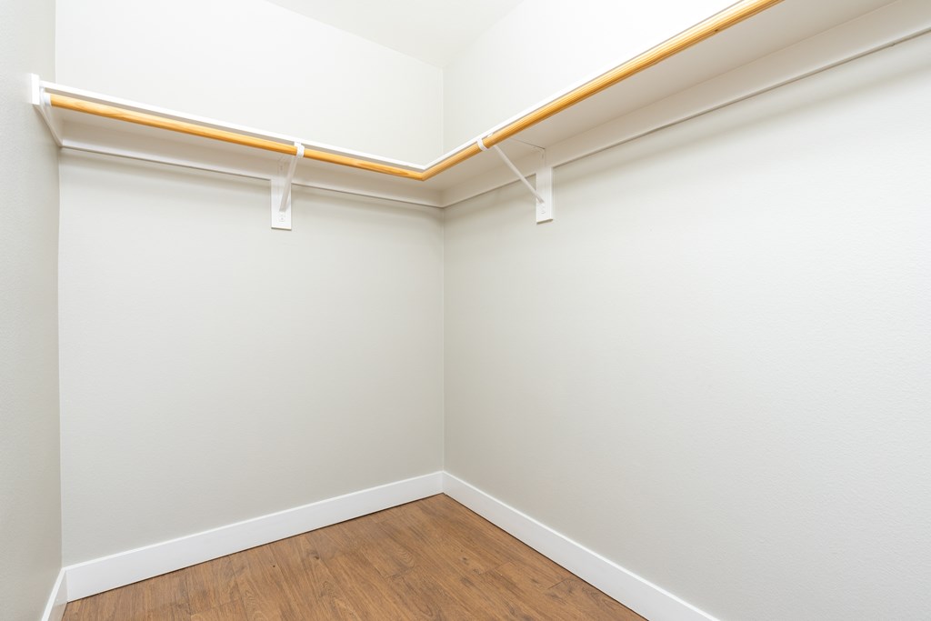 A room with a white wall and a wooden floor.