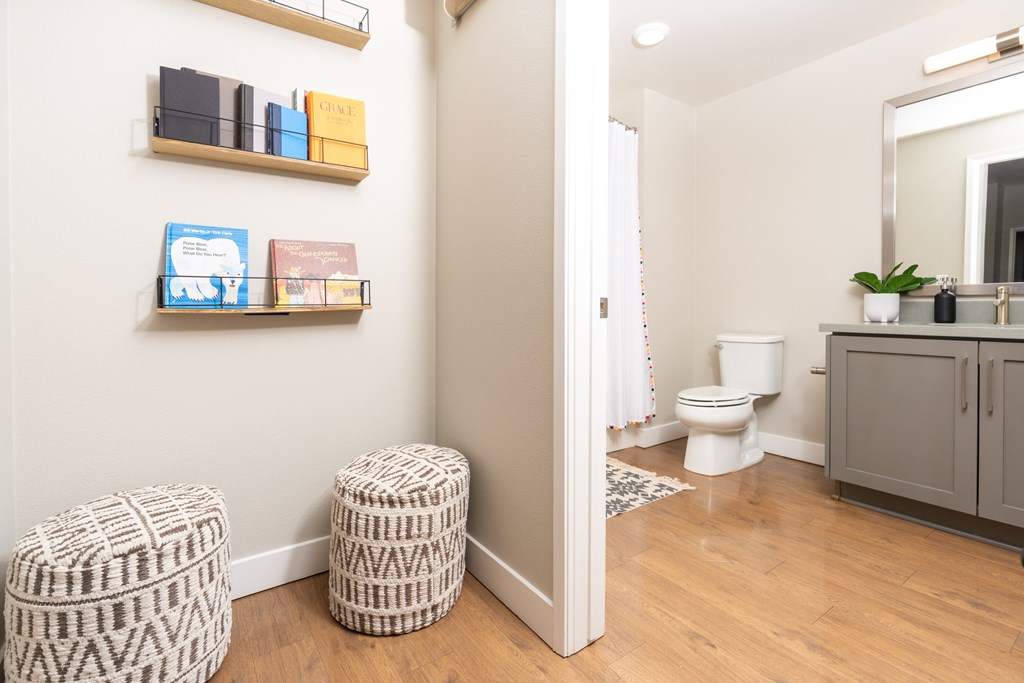 A bathroom with a toilet, a cabinet, and a mirror.