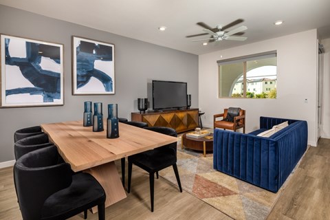 A modern living room with a wooden table and black chairs.