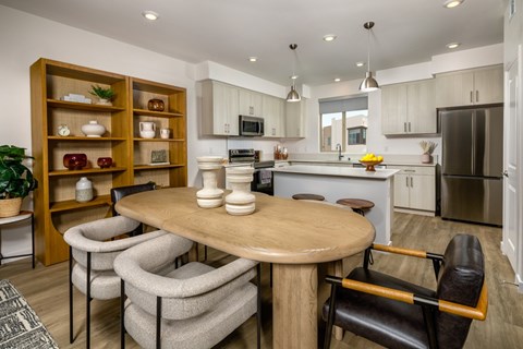 A modern kitchen with a wooden table and chairs.