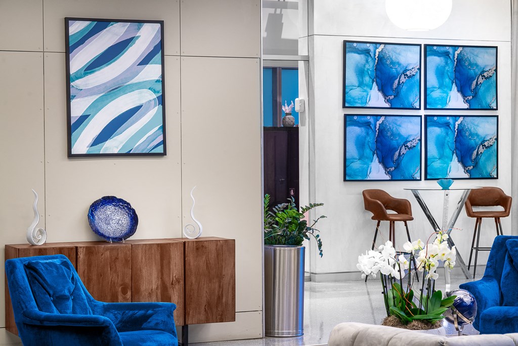 a living room with blue chairs and white flowers