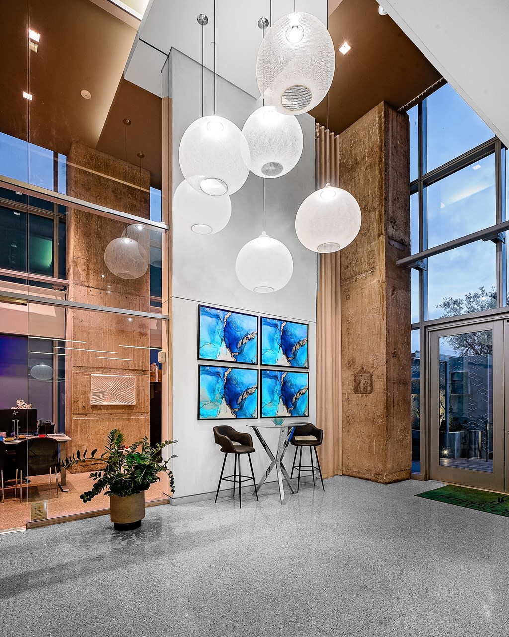 a view of the lobby with a large glass window and a large pendant light hanging from
