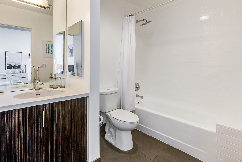 One-Bedroom Apartments in Hollywood, CA - Sunset Vine Tower - Bathroom with Mirror, Bathtub, and Grey Tiles