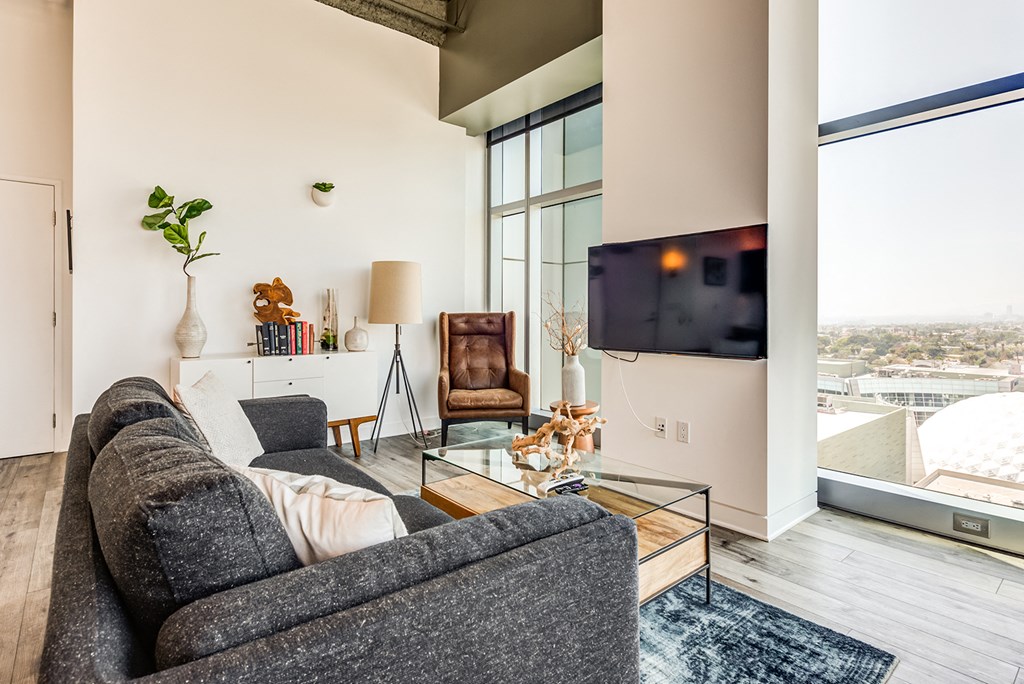 a living room with a gray couch and a glass coffee table