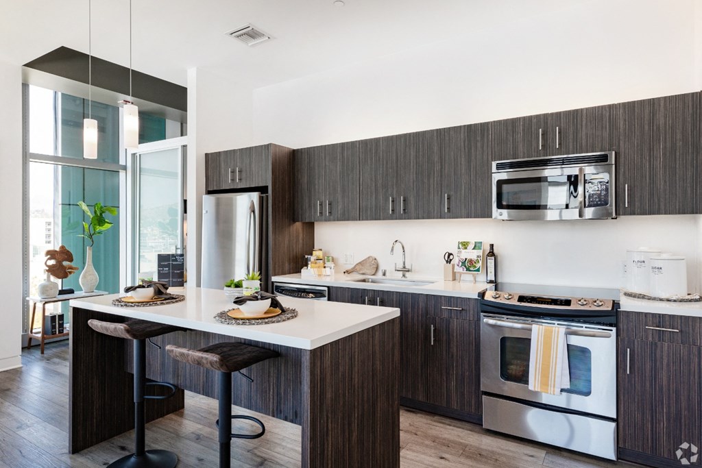 a kitchen with dark wood cabinets and white countertops