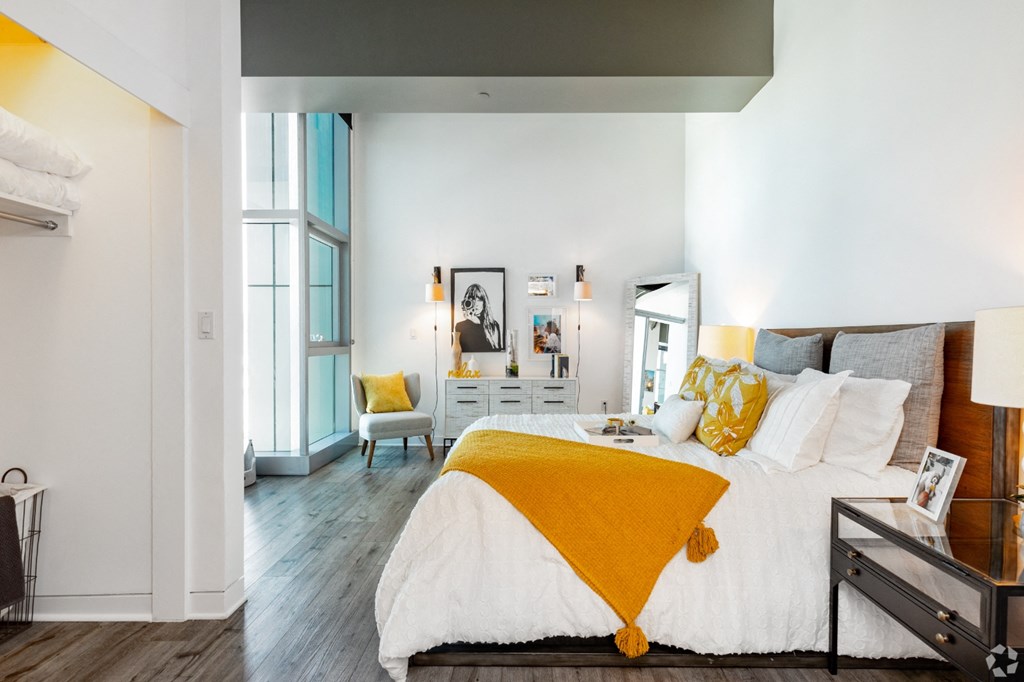 a bedroom with white walls and a yellow blanket on the bed