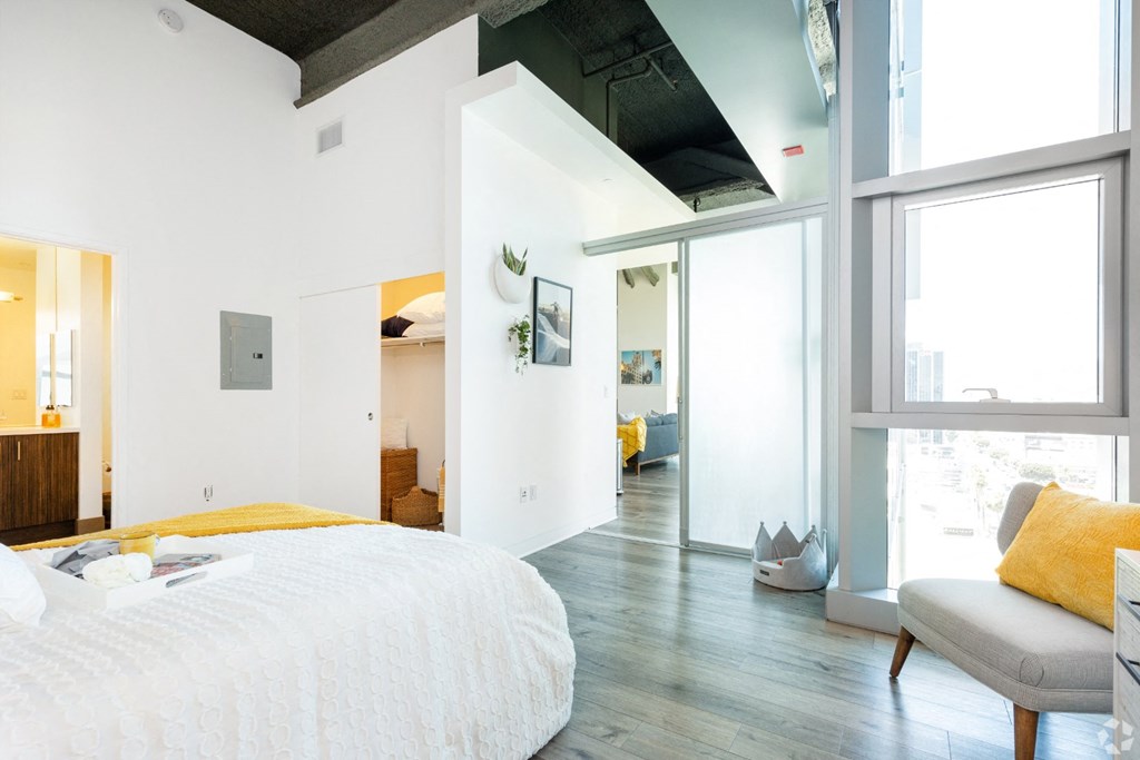 a bedroom with a bed sitting next to a window