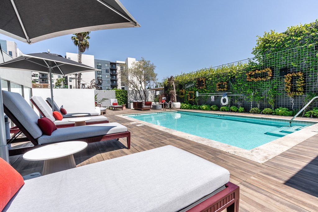 a pool and lounge area on a sunny day at a hotel in los angeles