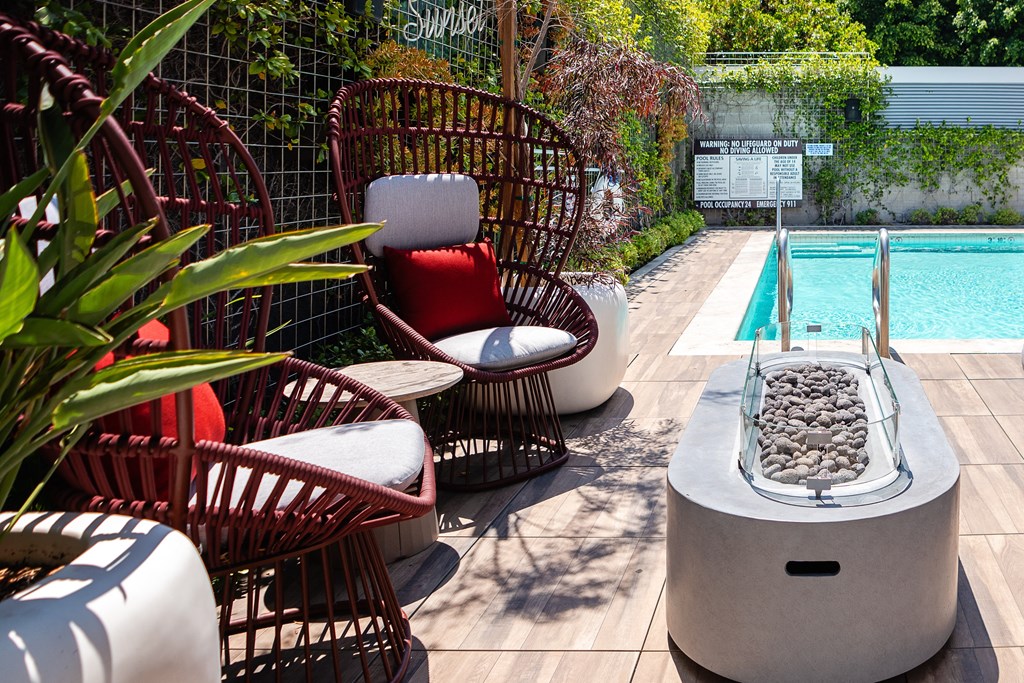 a pool with wicker chairs and a jacuzzi