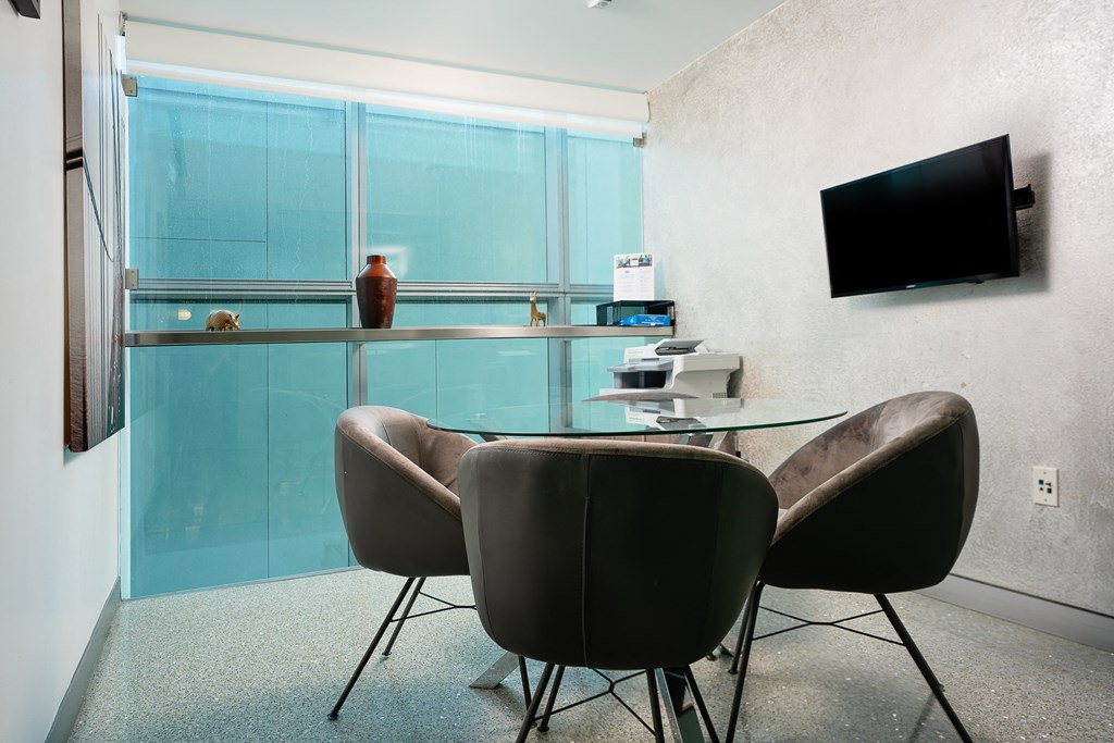 a room with a table and two chairs and a television on the wall