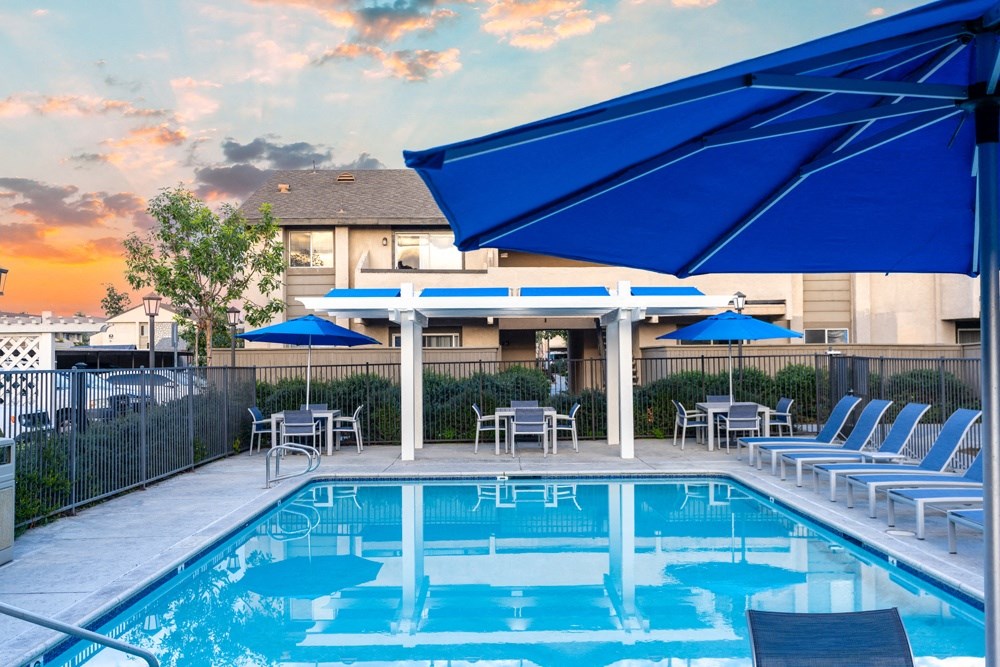 a swimming pool with chairs and umbrellas at Sunstone Place, California, 92505