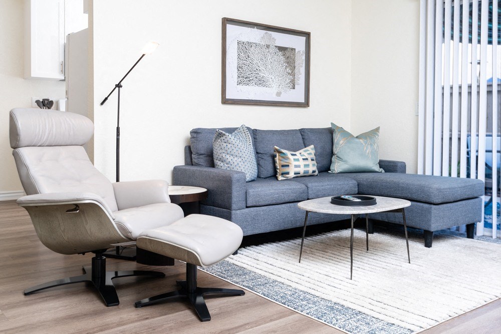 a living room with a blue couch and a white chair at Sunstone Place, Riverside, 92505