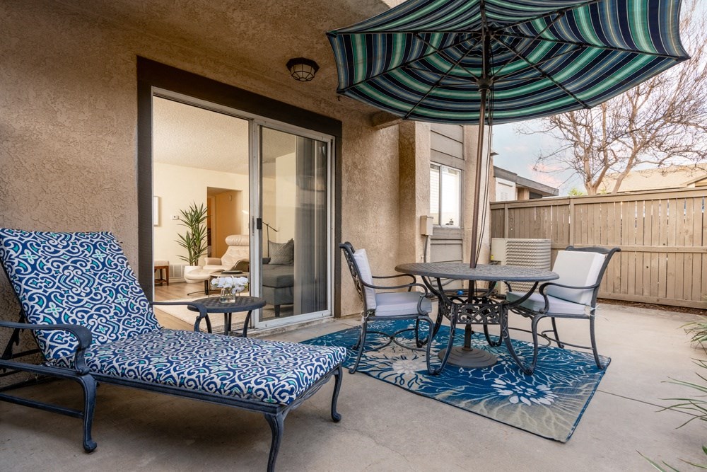 a patio with chairs and tables and an umbrella at Sunstone Place, Riverside, CA