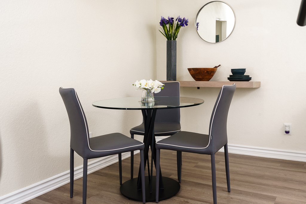 a round table with two chairs and a mirror on the wall at Sunstone Place, Riverside, CA