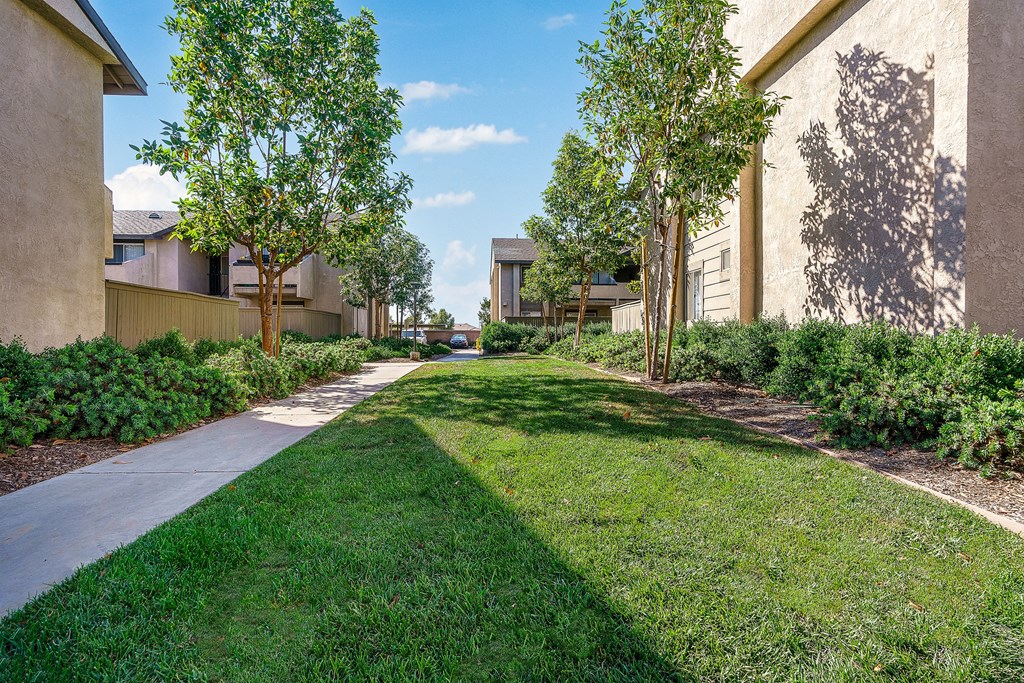 a grassy area with trees and buildings on either side at Sunstone Place, Riverside, 92505