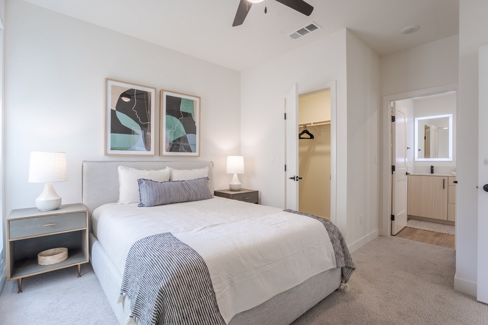 A bedroom with a large bed and a ceiling fan.