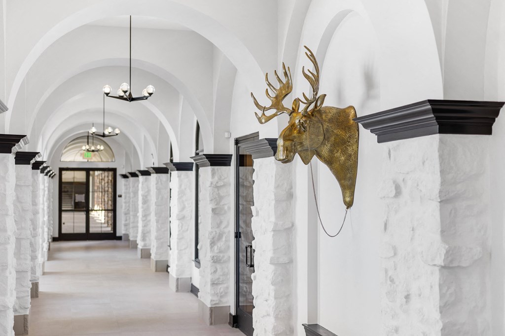 a hallway with white marble pillars and a deer head on the wall at Terracina, Broomfield, CO